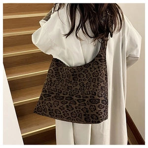 Detail of large leopard print tote bag in soft suede fabric worn over a beige winter coat