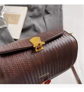 Close-up of retro woven leather box bag with gold shell clasp and textured finish
