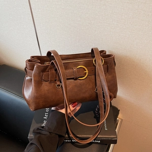 Retro brown Boston shoulder bag with gold hardware detail on a minimalist background
