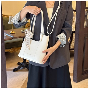 White lychee leather tote bag featuring a decorative checkered ribbon and crossbody strap