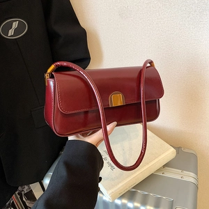 Retro dark red rectangular shoulder bag with golden buckle shown in a lifestyle setting
