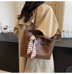Detail of dark brown tote bag with houndstooth silk scarf and thin leather shoulder strap