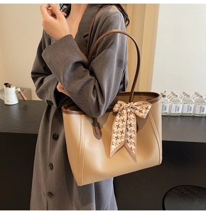 Close-up of stylish large tote bag with elegant houndstooth silk scarf and leather strap