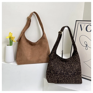 Detail of leopard print and brown suede shoulder bags with adjustable straps