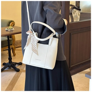 White lychee leather handbag with plaid silk scarf detail shown in a cafe setting