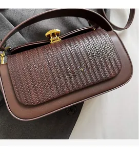 Detail of woven leather texture and gold flower clasp on a retro shoulder bag