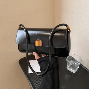 Sleek black glossy baguette bag with gold metal buckle for classic shoulder wear