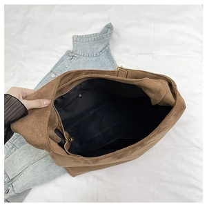 Detail view of large brown suede tote bag with spacious interior and inner zipper pocket