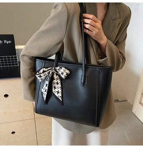 Detail of black tote bag with houndstooth ribbon and high-quality PU leather texture
