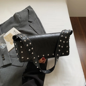 Minimalist black baguette bag with silver rivets and wide strap shown in a top-down view