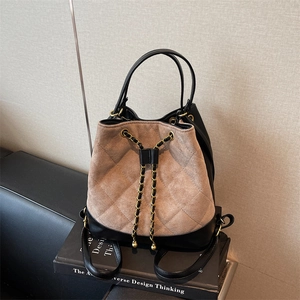 Quilted drawstring bucket backpack in black leather and beige suede with gold chains