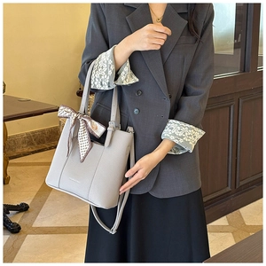 Grey pebbled leather tote bag with silk scarf accent styled with a professional blazer