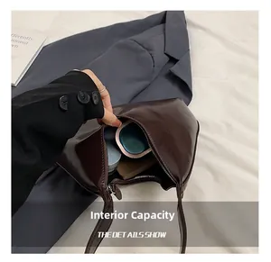 Détail intérieur d'un sac demi-lune marron foncé montrant l'espace de rangement