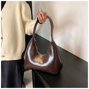Détail d'un sac demi-lune marron en similicuir mat montrant la texture et le logo FASHION