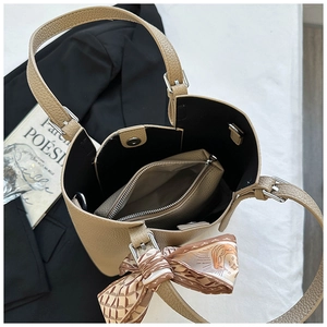 Detailed top view of khaki leather bucket bag with ribbon bow and inner pouch