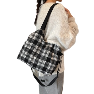 Fashionable black and white plaid tote bag with wide black straps in wool texture