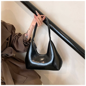 Detail of black glossy crescent bag showing the Fashion logo and sleek hobo design