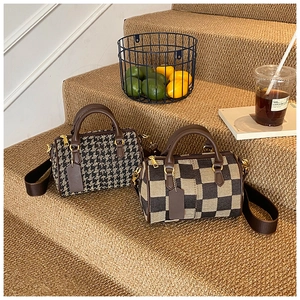 Detail of vintage houndstooth and checkered patterns on retro Boston barrel handbags