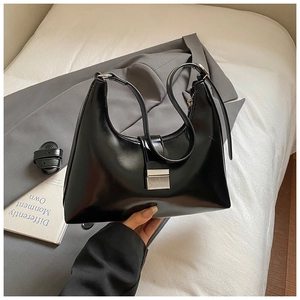 Detail van zwarte glanzende hobo-tas met zilveren gesp en verstelbare riem