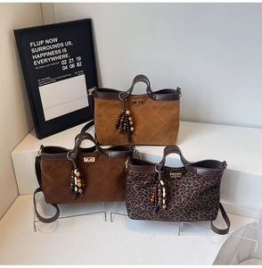 Three quilted tote bags in brown and leopard print with metal turn-lock and bead tassels
