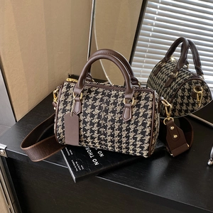 Detail of Boston bag showing houndstooth fabric texture, brown leather, and gold hardware