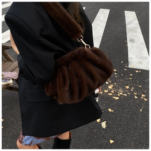 Detail of plush brown cloud bag with thick faux fur texture and golden metal hooks