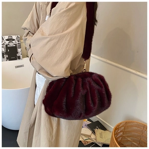 Burgundy faux fur pleated crossbody bag styled with a beige trench coat for autumn