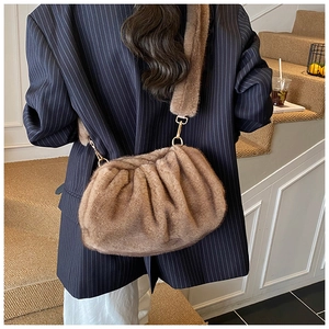 Detail view of brown plush crossbody bag with golden metal hardware and fluffy strap