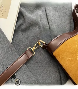 Detail of quilted mustard suede tote with premium gold-tone metal hardware and leather strap