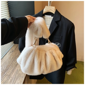 Detailed shot of cream faux fur crossbody bag with soft pleated texture and gold hardware