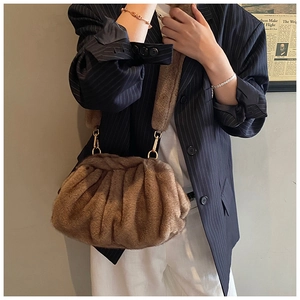 Detail of plush brown faux fur crossbody bag with premium gold metal buckles and soft texture