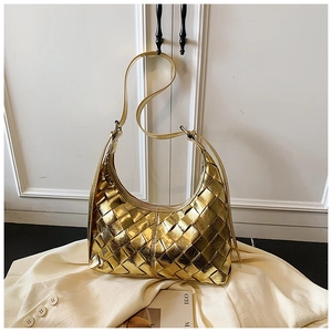 Detailansicht der gewebten goldenen Hobo-Schultertasche auf minimalistischem Grund