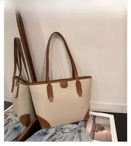 Detail shot of the pebble grain leather texture on this stylish beige and brown tote bag