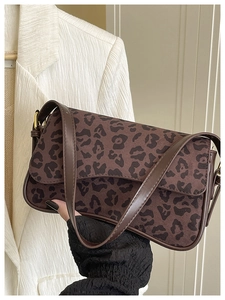 Detail shot of brown leopard print baguette bag with matte suede texture and leather strap