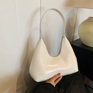 Minimalist ivory moon-shaped hobo bag with glossy finish and fashion logo embossing