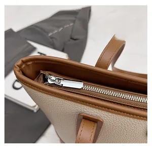 Macro shot of smooth silver zipper and stitching on lychee texture tote handbag