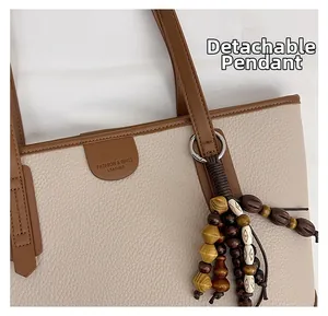 Detail of pebble leather tote bag with detachable beaded charm and fashion embossing