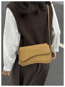 Detail of camel frosted suede shoulder bag with asymmetrical flap and gold metal buckle