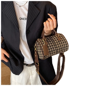 Chic houndstooth Boston handbag with brown leather handles and gold hardware