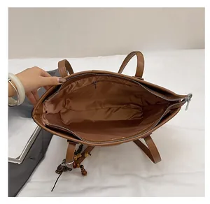 Internal structure of brown leather tote bag showing zipper closure and lining detail