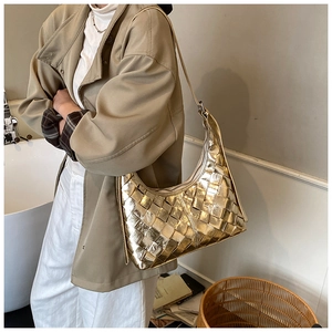 Nahaufnahme der goldenen Hobo-Tasche mit Metallic-Textur und breiter Webverarbeitung