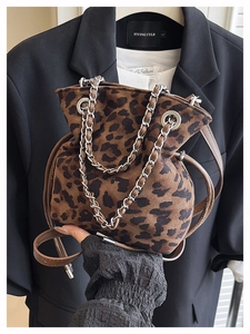Close-up of leopard print drawstring bucket bag with silver chain and suede texture