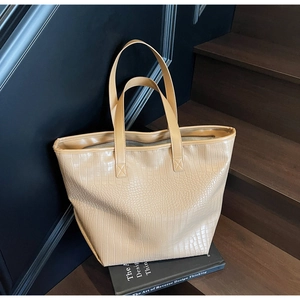 Detail of stone pattern texture on a large capacity tote bag displayed on wooden stairs
