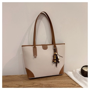 Detail of lychee pattern tote bag with wood bead tassel and contrast piping