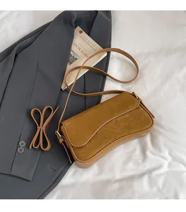 Brown matte suede rectangular flap bag on a white textured background with a blazer
