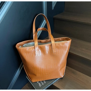 Close-up of brown crocodile texture leather tote bag with sturdy double handles