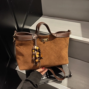 Brown quilted suede tote bag with metal twist lock and vintage wood bead charm accessory