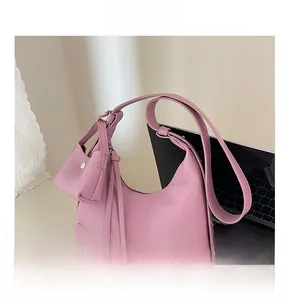 Rosa Hobo-Tasche mit Kiesel-Lederstruktur und passendem Minibeutel auf einem Schreibtisch