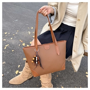 Brown lychee grain leather tote bag with round logo and vintage wooden bead tassel detail
