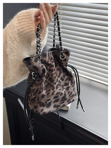 Detail of leopard print bucket bag with metal chain strap and drawstring closure